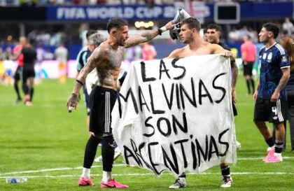 Giovani Lo Celso dari Argentina memegang spanduk bertuliskan Keluarga Malvinas adalah orang Argentina. (Foto: Rebecca Blackwell/AP)