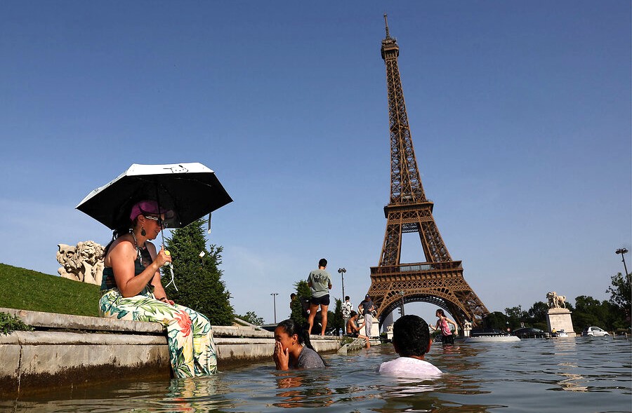 Sejumlah warga berendam di sungai di kawasan Menara Eiffel, Paris, Prancis. (Foto: REUTERS)