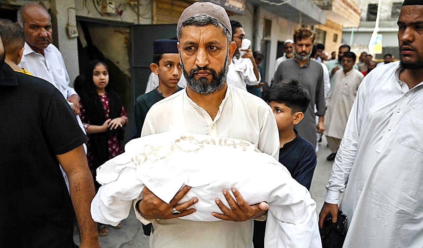 Seorang pria membawa jenazah bayi baru lahir yang meninggal akibat kebakaran di Rumah Sakit Pakistan Institute of Medical Sciences, Islamabad, Pakistan, Rabu (26/8/2026). (Foto: AFP)