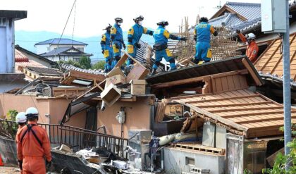 Petugas penyelamat berdiri di atas rumah yang runtuh. Gempa berkekuatan magnitudo 7,1 menyebabkan kerusakan luas pada rumah-rumah dan jaringan listrik di seluruh Prefektur Kumamoto, Jepang. (Foto: AFP/Getty Images)