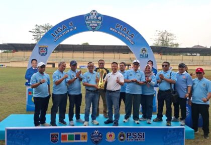 Walikota Depok, Supian Suri (kaos putih), menyerahkan piala yang diperebutkan di turnamen sepakbola Liga 4 kepada Kepala Dinas Poryata Eko Herwiyanto di Stadion Merpati, Kelurahan Depok Jaya, Kecamatan Pancoran Mas, Minggu (30/8) sore. (Foto: Diskominfo)