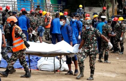 Tim penyelamat mengangkut jenazah korban yang terjebak di bawah tanah longsor di Kathmandu, Nepal. (Foto: Sujan Gurung/AP)